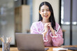 © David - Photo of cheerful joyful young asian business woman in the office working on laptop digital project sitting at desk.