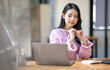 © David - Photo of cheerful joyful young asian business woman in the office working on laptop digital project sitting at desk.