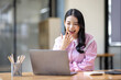 © David - Photo of cheerful joyful young asian business woman in the office working on laptop digital project sitting at desk.