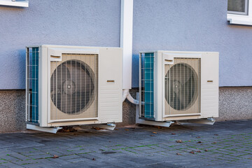 Wall Mural - Two air source heat pumps installed outside of new and modern city house, green renewable energy concept of heat pump