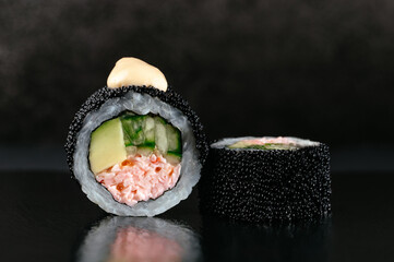 Poster - Japanese sushi rolls in tobiko caviar on a dark background with