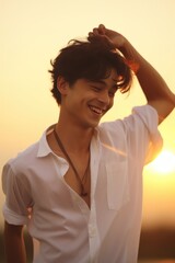 Aufkleber - A man in a white shirt smiles as the sun sets. Perfect for capturing the beauty of nature and the joy of the moment