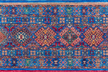 Wall Mural - Pattern of traditional Turkish carpet. Multicolor fragment, blue and red ornament. Kushadasi, Turkey (Turkiye)