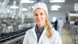 © BlazingDesigns - Portrait of pretty caucasian female technologist wearing white coat checking quality at a food factory and doing quality control.