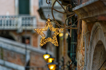 Old town of City of Venice with close up of illuminated star decoration hanging from facade on a blue cloudy summer day. Photo taken August 6th, 2023, Venice, Italy.