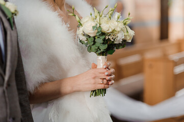 Wall Mural - A beautiful wedding bouquet in the hands of the bride. Bouquet with white flowers in the hands of the bride