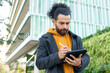 © ADDICTIVE STOCK - Focused man using tablet outdoors in urban setting