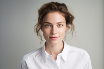 Portrait of a tender woman in her 30s wearing a classic white shirt against a white background. AI Generation