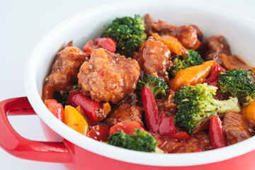 Wall Mural - Stewed chicken fillet with vegetables in pan, white background.