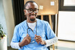 © LIGHTFIELD STUDIOS - joyful young african american doctor with stethoscope and glasses smiling and looking at camera
