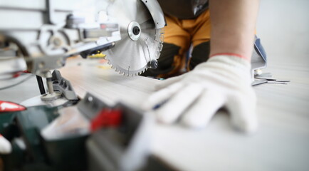 Wall Mural - Close-up of professional foreman working with metal electrical equipment. Man in protective white gloves for work. Detailed picture. Renovation and construction site concept