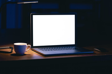 Blank screen workspace with computer laptop on table at night, copy space.