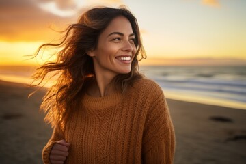 Wall Mural - Portrait of a cheerful woman in her 30s dressed in a warm wool sweater against a stunning sunset beach background. AI Generation