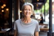 © Markus Schröder - Portrait of a satisfied woman in her 50s dressed in a casual t-shirt against a bustling restaurant background. AI Generation