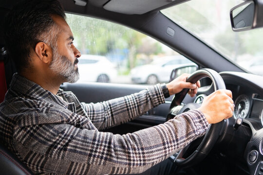 Concentrated Indian man driving car