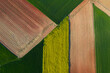 © ADDICTIVE STOCK - Textured aerial view of farmland showing geometric patterns of plowed fields in green, yellow, and brown tones
