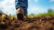 Harvesting Dreams: A Person Sowing Seeds in Fertile Dark Brown Soil. The concept revolves around the cycle of life, growth, and abundance as represented by a person actively sowing seeds in rich soil.