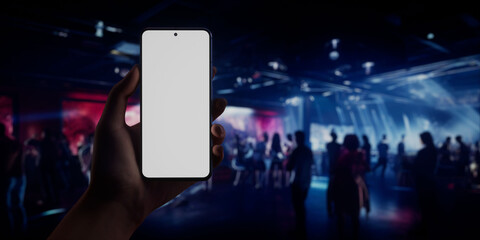 Caucasian woman holding phone, night club in the background, blank screen mockup