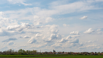 Wall Mural - village and field in vojvodina in spring and white clouds