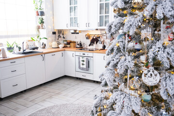 Wall Mural - Christmas decor in white kitchen, festive mess, village interior with a snowy Christmas tree and fairy lights. New Year, Christmas mood, cozy home. 