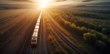 Aerial View Of A Freight Train Passing Through The Forest At Sunset.