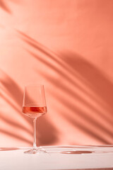 Glasses with rose wine or champaign on peach fuzz color background. Color of the year 2024 concept. High quality photo