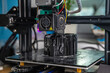 A 3D printer prints a black model. Technology at home