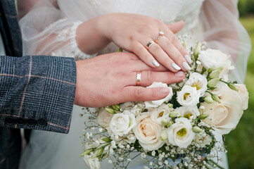 Wall Mural - Hands of the bride and groom on a wedding bouquet