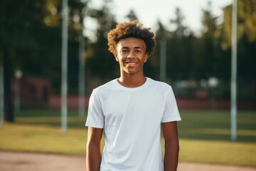 Wall Mural - Portrait of a smiling young man on tennis court