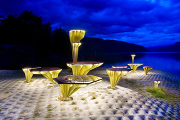 Wall Mural - Illuminated chairs and tables built from materials from recycled plastic boats on the shore of Sandsfjorden in Ropeid, Norway