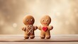  a couple of gingerbread man and woman standing next to each other on a wooden table with a blurry background.