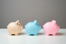 Three piggy banks lined up in a chain. Savings management. Reinvest part of the profits. Dividing the savings into parts. Diversification of income and financial receipts. Movement of capital