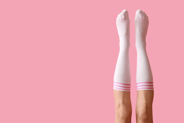Wall Mural - Legs of young woman in white socks on pink background