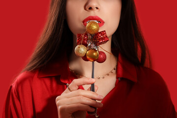 Sticker - Beautiful young woman with fork, mini gift boxes and Christmas balls on red background