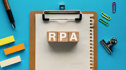 Poster - There is wood cube with the word RPA. It is an abbreviation for Robotic Process Automation as eye-catching image.