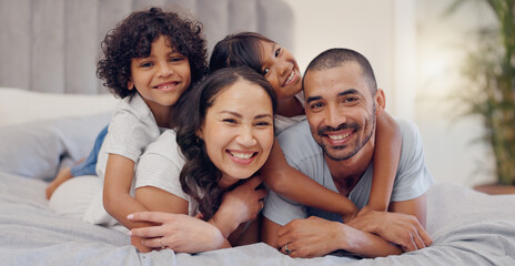 Poster - Portrait, smile and kids with parents in bed relaxing and bonding together at family home. Happy, fun and young mother and father laying and resting with children in bedroom of modern house.