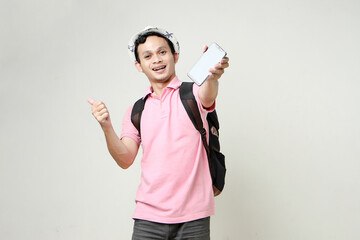 Asian man backpacker give thumb up and showing cellphone blank screen with empty space for mobile app on screen. travelling concept. on isolated background