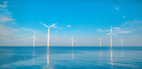 windmill turbines generating electric green energy with a blue sky green energy concept in the nethe