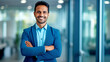 © PETR BABKIN - Smiling Indian businessman on blurred office background