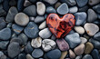 A striking red heart-shaped stone stands out among a bed of smooth river pebbles