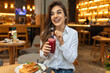 Cute young woman taking a smoothie break at a juice bar, Cheerful young woman having lunch and healthy smoothies at a juice bar
