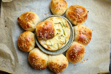 Poster - closeup of freshly baked bread buns with melted brie