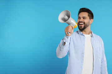 Poster - Special promotion. Smiling man with megaphone on light blue background. Space for text