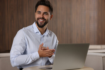 Poster - Happy young man with laptop at table in office