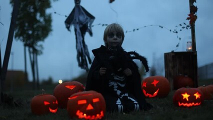 Poster - Two boys in the park with Halloween costumes, carved pumpkins with candles and decoration, playing