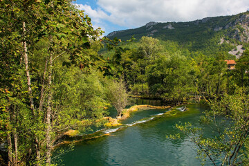 Wall Mural - Travertine pools in the River Una as it flows away from the Small Waterfalls at Martin Brod in Una-Sana Canton, Federation of Bosnia and Herzegovina. Located within the Una National Park. Early Sept