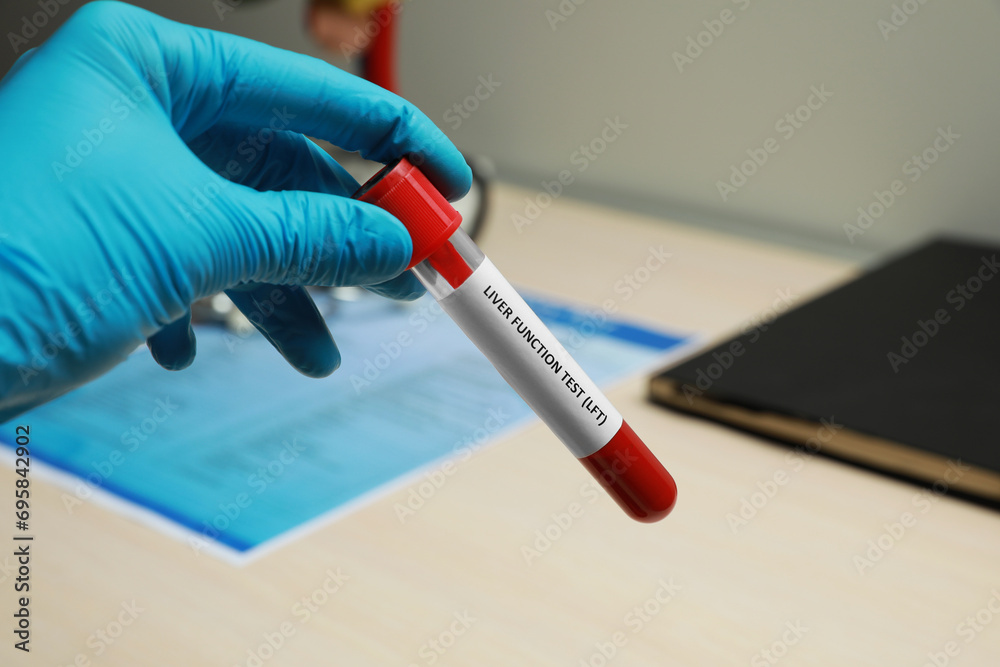 Laboratory worker holding tube with blood sample and label Liver ...