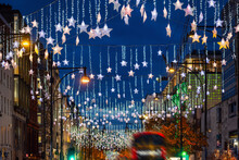 Festive Christmas Decorations In The Streets Of London With Red Bus Traffic During Night Time