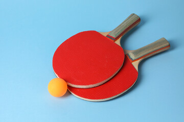 Poster - Ping pong ball and rackets on light blue background