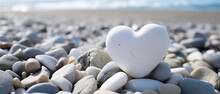 A Beautiful White Stone In The Shape Of A Heart, On A Stone Beach, With Empty Copy Space